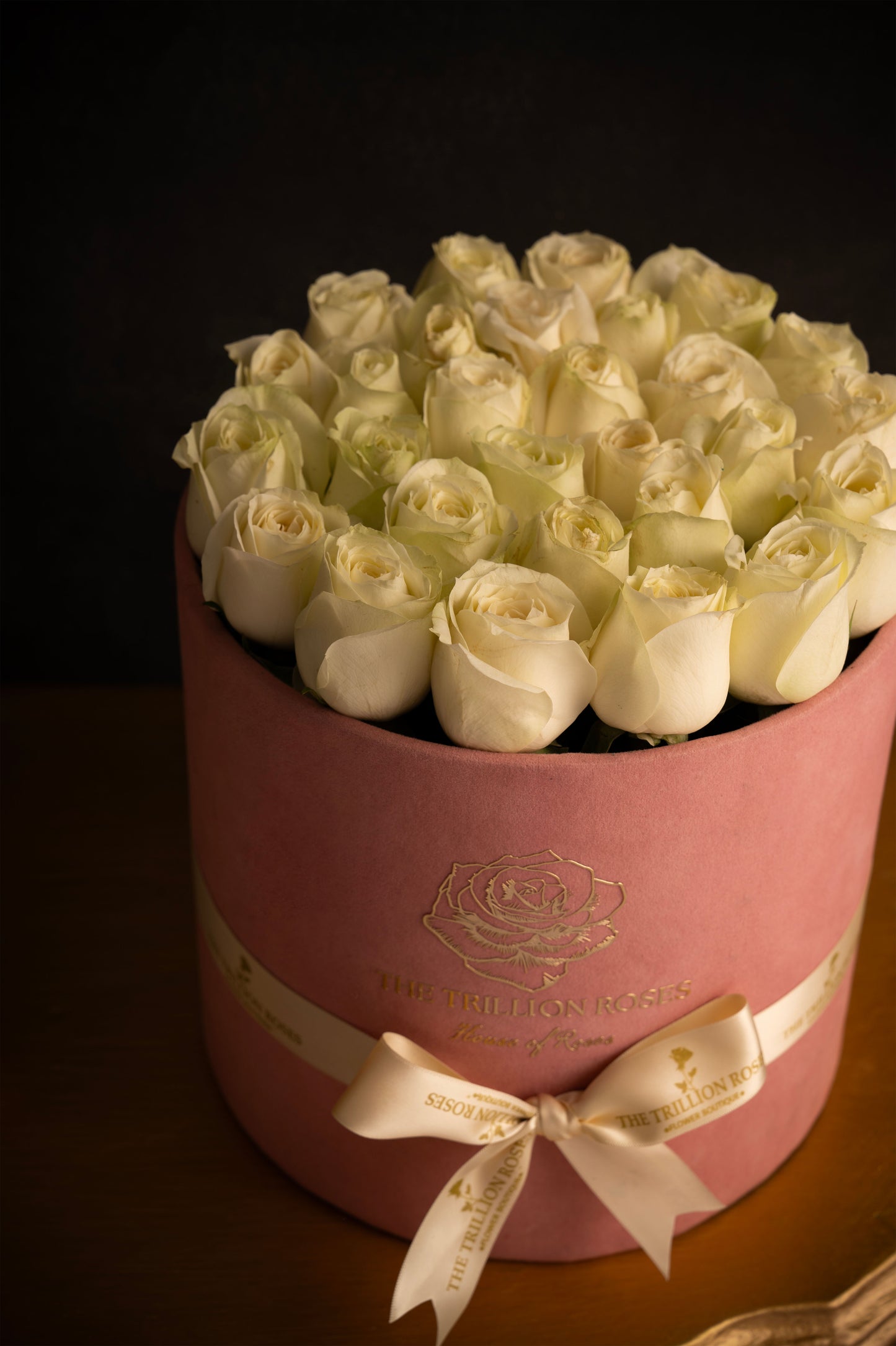 SNOW WHITE ROSES IN PINK ROUND BOX.